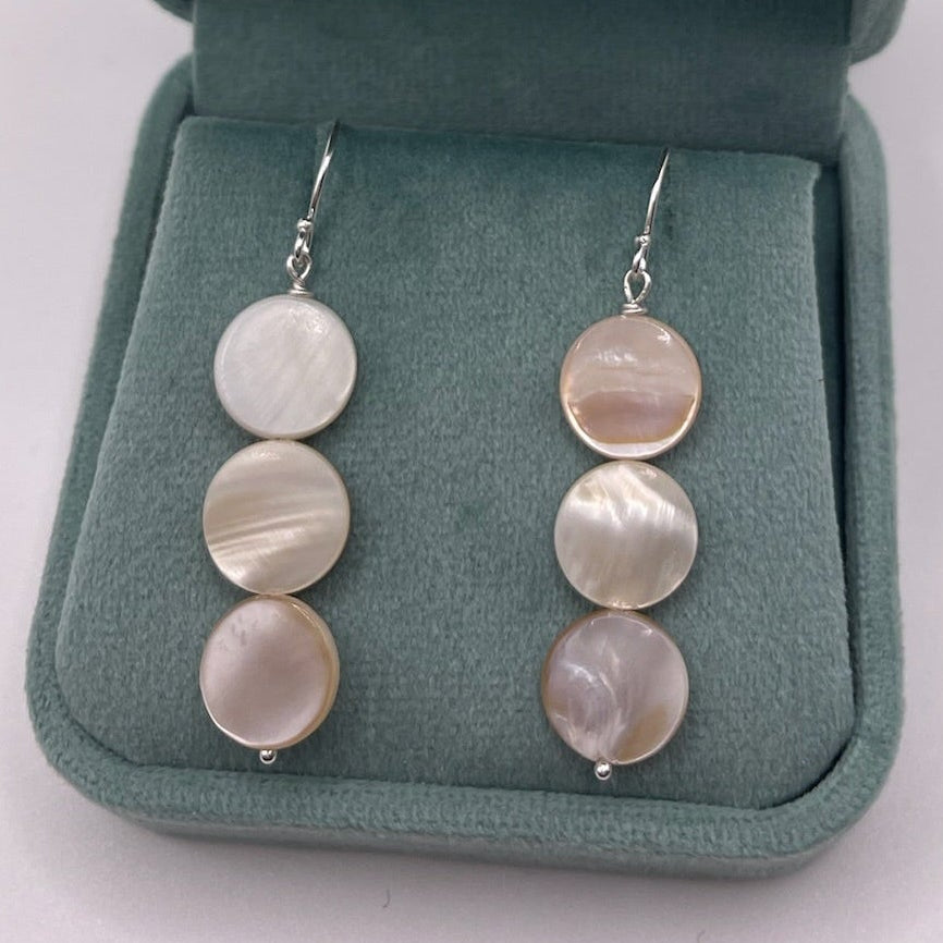 Pair of earrings in a green jewelry box on a white background